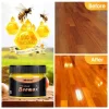 Natural beeswax furniture polish in a round tin, used for wood care and shine restoration, placed on a polished wooden surface.